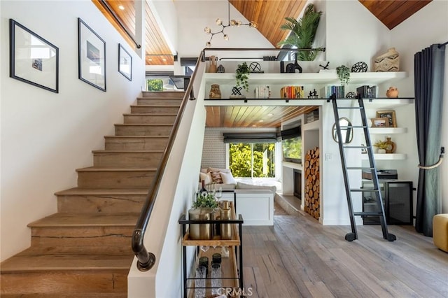 stairs featuring hardwood / wood-style floors, high vaulted ceiling, and wooden ceiling