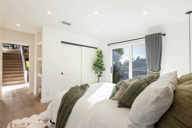 bedroom with access to outside, a closet, and hardwood / wood-style floors