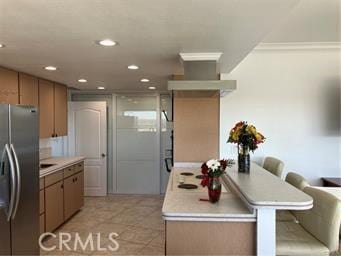 10 Hilltop, Barstow, CA 92311 - kitchen with a kitchen bar, light countertops, recessed lighting, stainless steel refrigerator with ice dispenser, and light tile patterned flooring