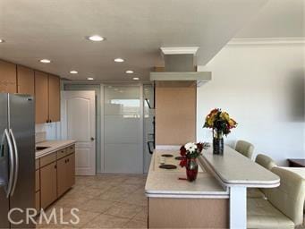 10 Hilltop, Barstow, CA 92311 - kitchen featuring recessed lighting, stainless steel fridge, a breakfast bar area, light countertops, and light tile patterned floors