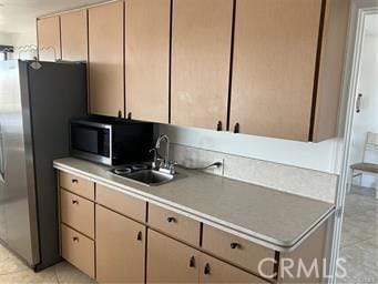 10 Hilltop, Barstow, CA 92311 - kitchen with light tile patterned floors, appliances with stainless steel finishes, light countertops, and a sink