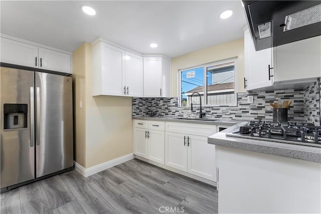 kitchen featuring sink, white cabinets, light wood-type flooring, and appliances with stainless steel finishes