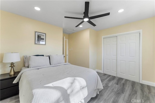 bedroom featuring ceiling fan, a closet, and light hardwood / wood-style flooring