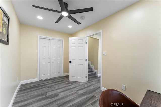 unfurnished bedroom with dark hardwood / wood-style flooring, ceiling fan, and a closet