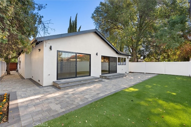 rear view of property with a yard and a patio