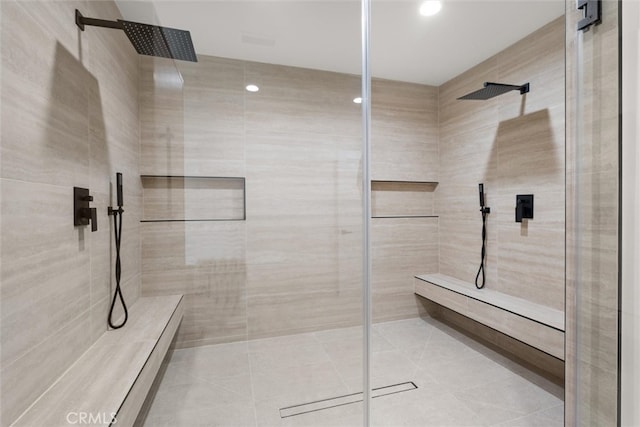 bathroom with tiled shower and tile patterned flooring