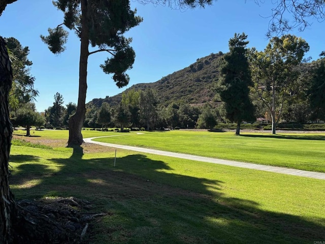 surrounding community with a lawn and a mountain view