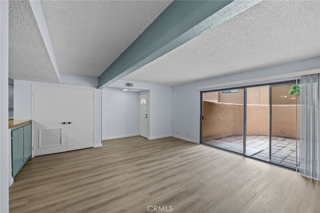 interior space featuring wood-type flooring and a textured ceiling