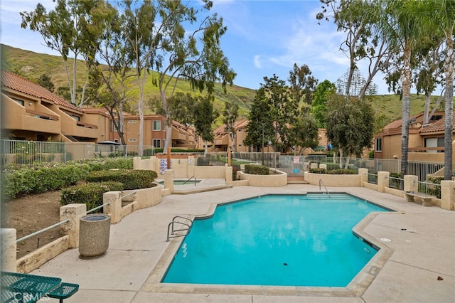 view of pool featuring a mountain view and a patio