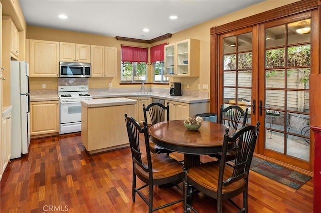 kitchen with a center island, sink, dark wood-type flooring, appliances with stainless steel finishes, and french doors