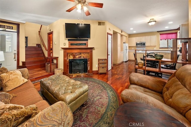 living room featuring ceiling fan, hardwood / wood-style floors, and a high end fireplace