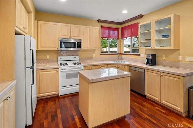 kitchen featuring dark hardwood / wood-style flooring, sink, stainless steel appliances, and a center island