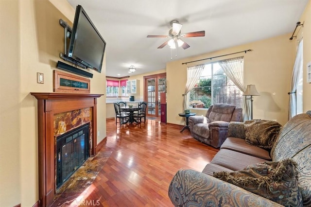 living room with ceiling fan, hardwood / wood-style floors, and a high end fireplace