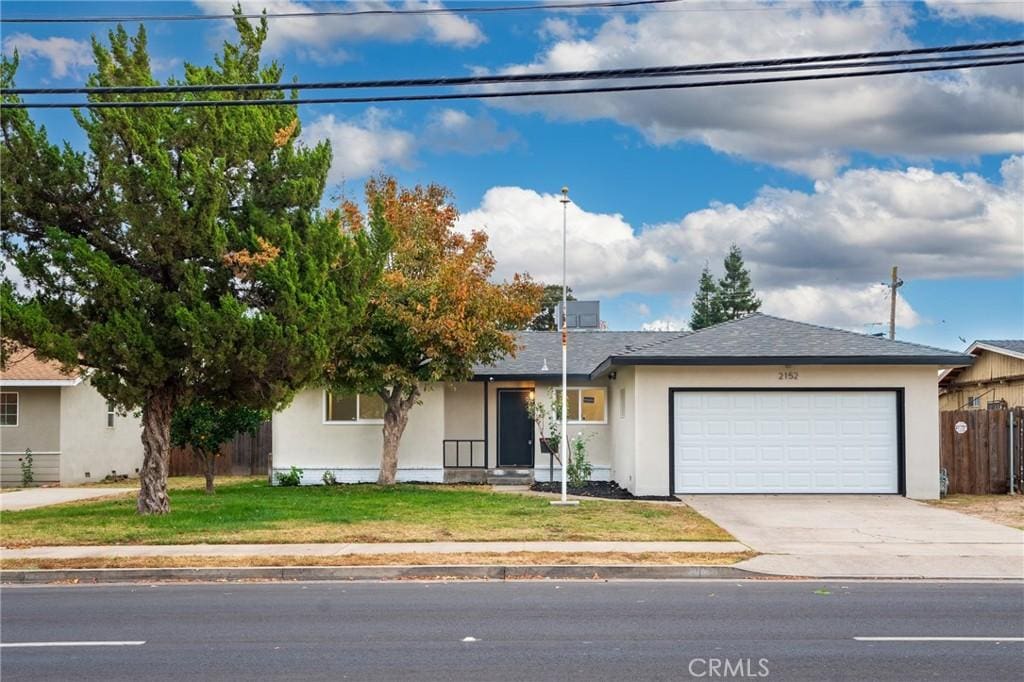 single story home with a front yard and a garage