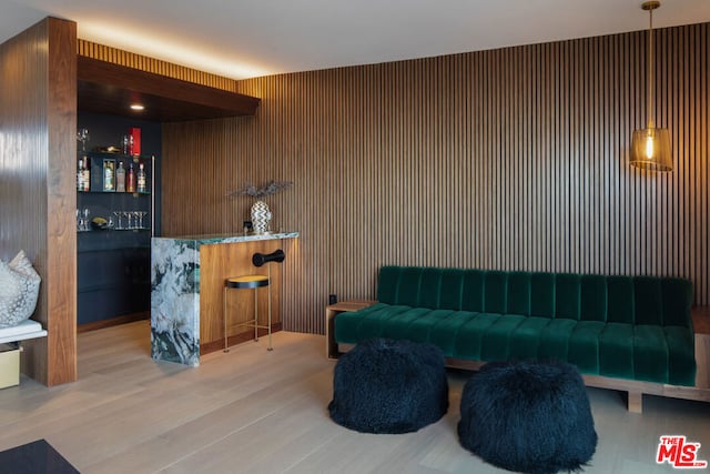 sitting room featuring hardwood / wood-style flooring and bar