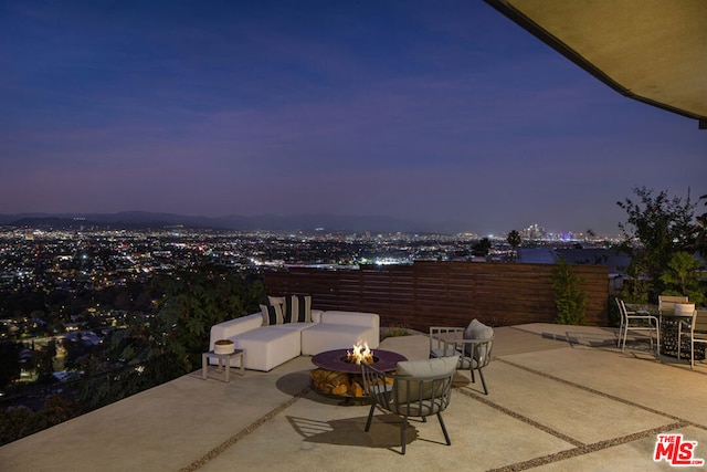 patio terrace at dusk featuring a fire pit