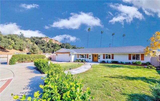 ranch-style home featuring a garage and a front yard