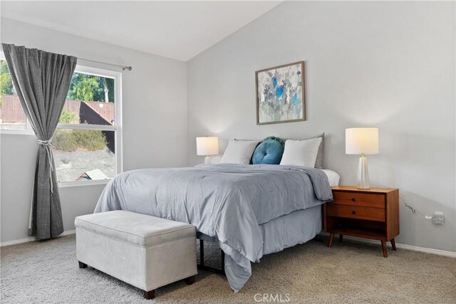 bedroom featuring light carpet and vaulted ceiling