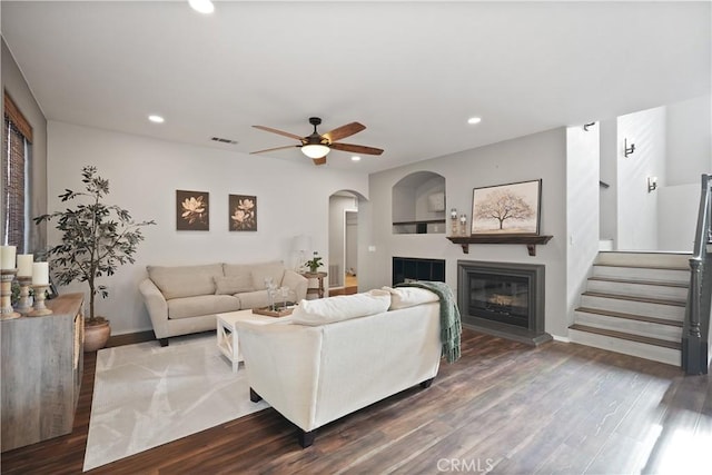 living room featuring ceiling fan and dark wood-type flooring