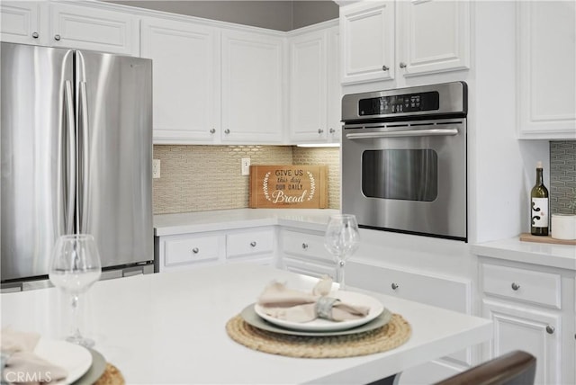 kitchen featuring backsplash, white cabinetry, and stainless steel appliances