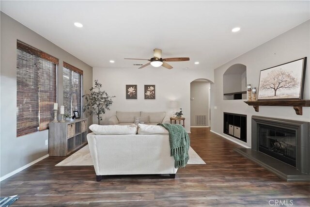 living room featuring ceiling fan and dark wood-type flooring