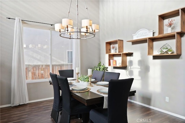 dining room with dark hardwood / wood-style floors and an inviting chandelier