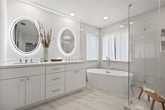 bathroom with vanity and shower with separate bathtub