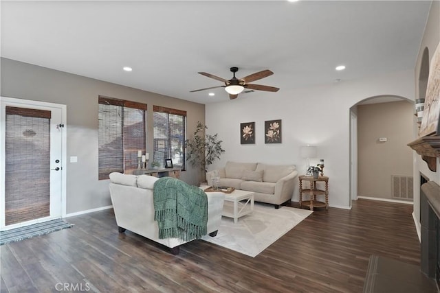 living room with ceiling fan and dark wood-type flooring