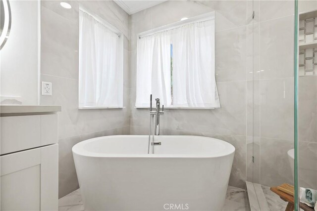 bathroom featuring a bathtub and tile walls