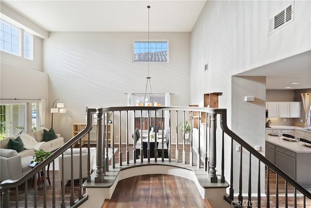 staircase with a towering ceiling and an inviting chandelier