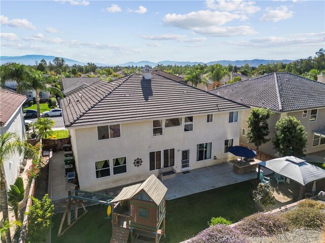 rear view of house with a mountain view and a patio area