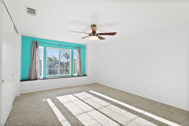 carpeted empty room featuring ceiling fan