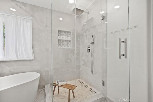 bathroom with tile walls and independent shower and bath