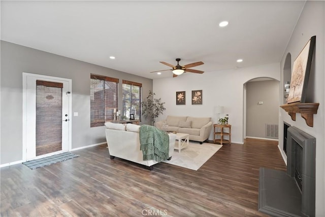 living room with ceiling fan and dark wood-type flooring