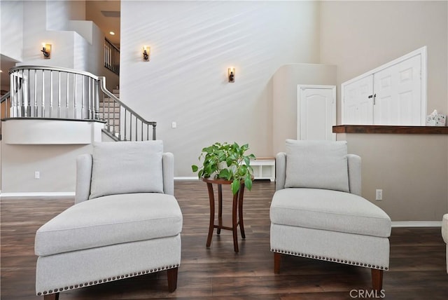 sitting room with dark hardwood / wood-style flooring and a high ceiling