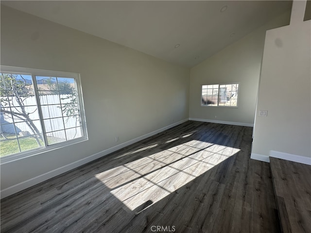 spare room featuring dark hardwood / wood-style flooring and high vaulted ceiling