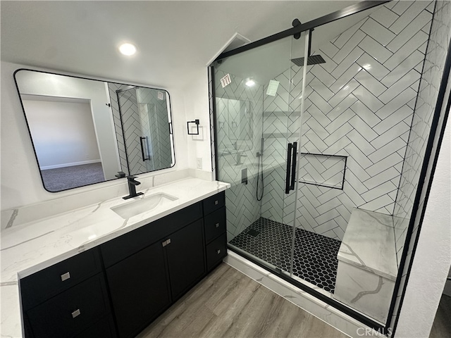 bathroom featuring vanity, hardwood / wood-style flooring, and a shower with shower door