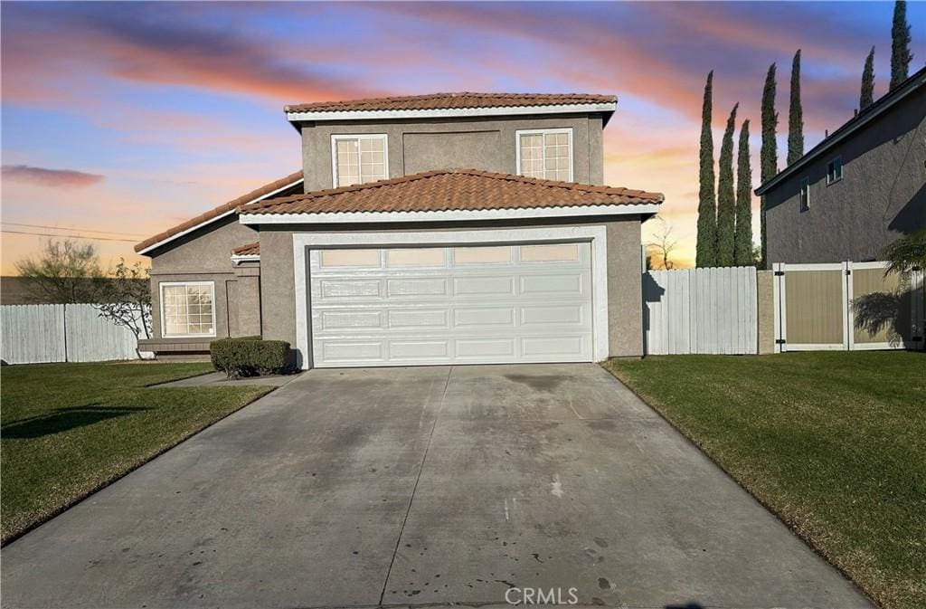 view of front of home featuring a garage and a lawn