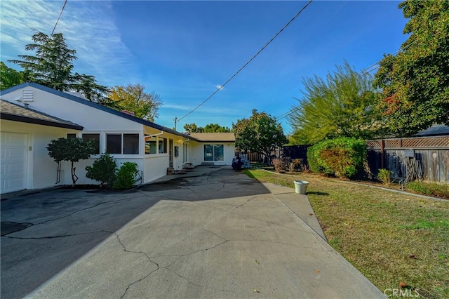 exterior space with a garage and a front lawn