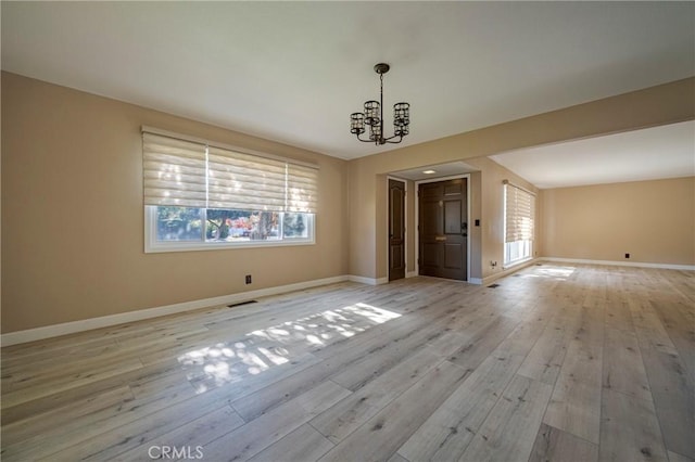 unfurnished dining area with light hardwood / wood-style floors and a notable chandelier