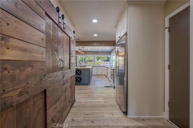 corridor featuring a barn door and light wood-type flooring