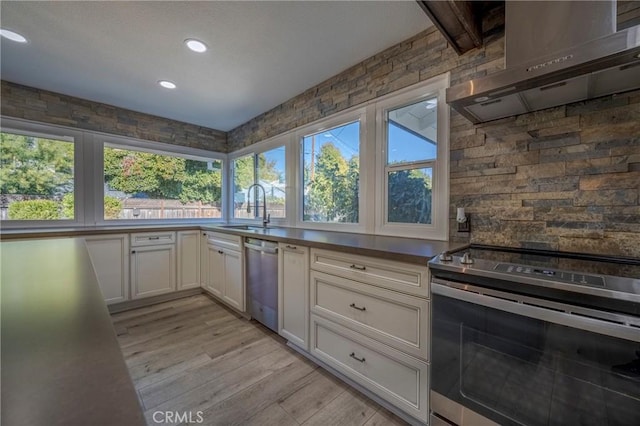 kitchen with stainless steel appliances, light hardwood / wood-style floors, a healthy amount of sunlight, and sink