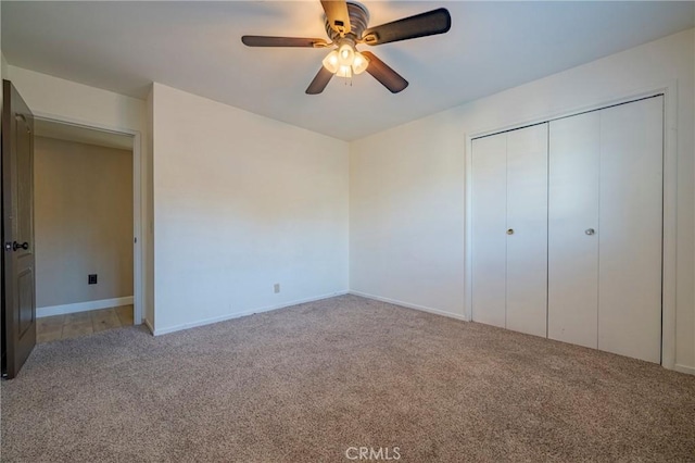 unfurnished bedroom featuring ceiling fan, light carpet, and a closet