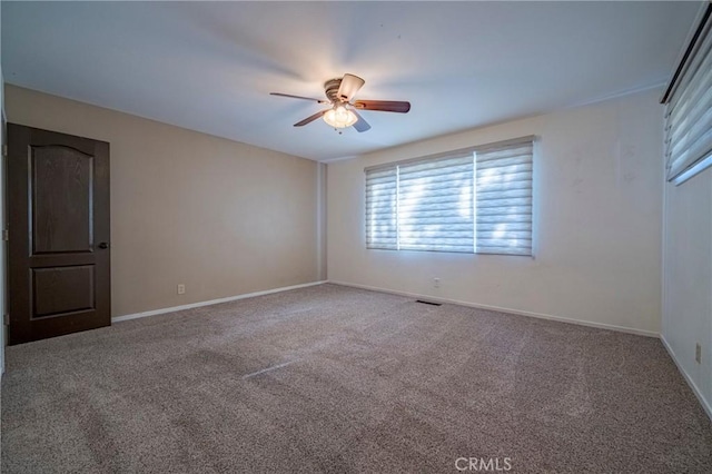 carpeted spare room with ceiling fan