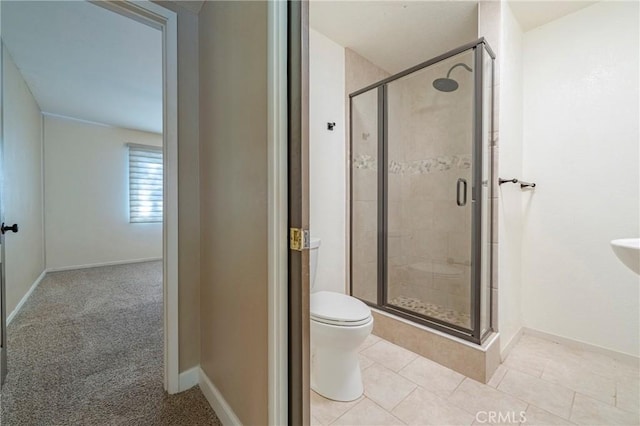 bathroom featuring tile patterned flooring, toilet, and an enclosed shower