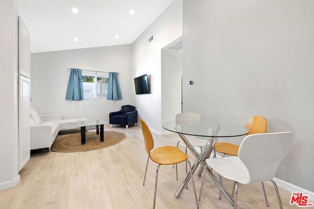 dining space featuring lofted ceiling and light wood-type flooring