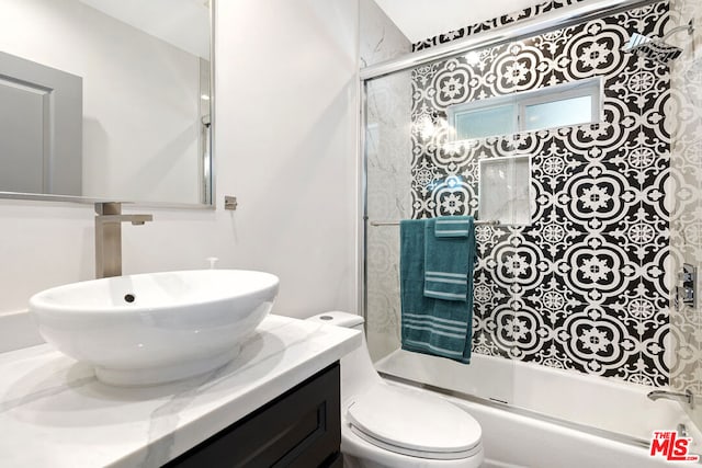 full bathroom featuring toilet, vanity, and combined bath / shower with glass door