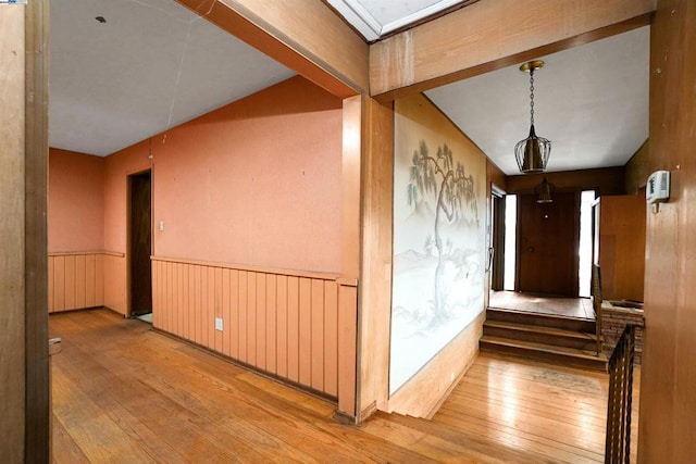 hallway featuring lofted ceiling and light hardwood / wood-style flooring