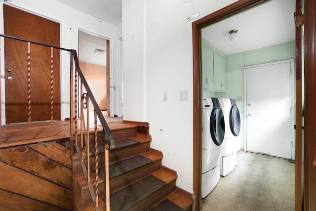 clothes washing area featuring cabinets and washing machine and clothes dryer