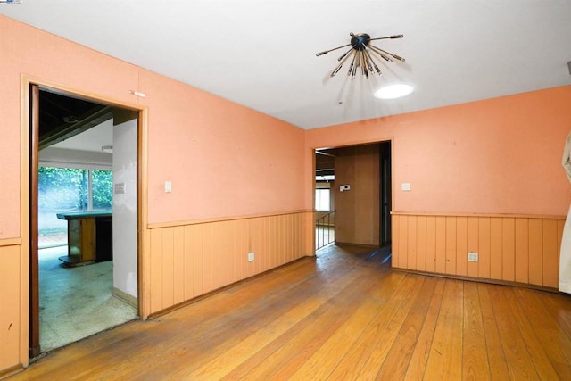 unfurnished room featuring hardwood / wood-style floors and a notable chandelier